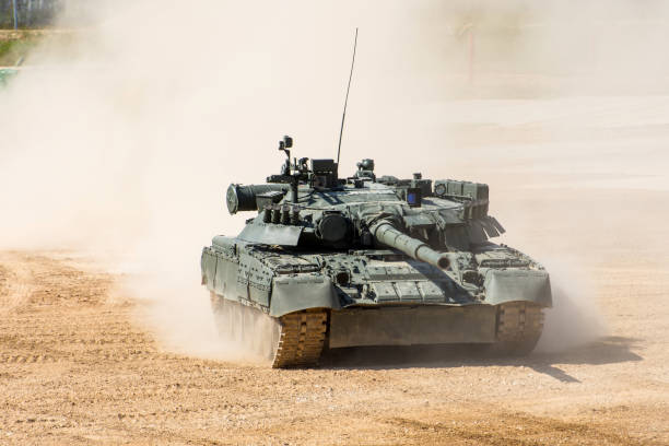 powerful military tank rides at a high speed along the dusty field